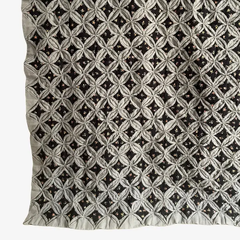 Vintage Cathedral Windows quilt in black and charcoal colors. the classic folded window pattern with layered fabric details.